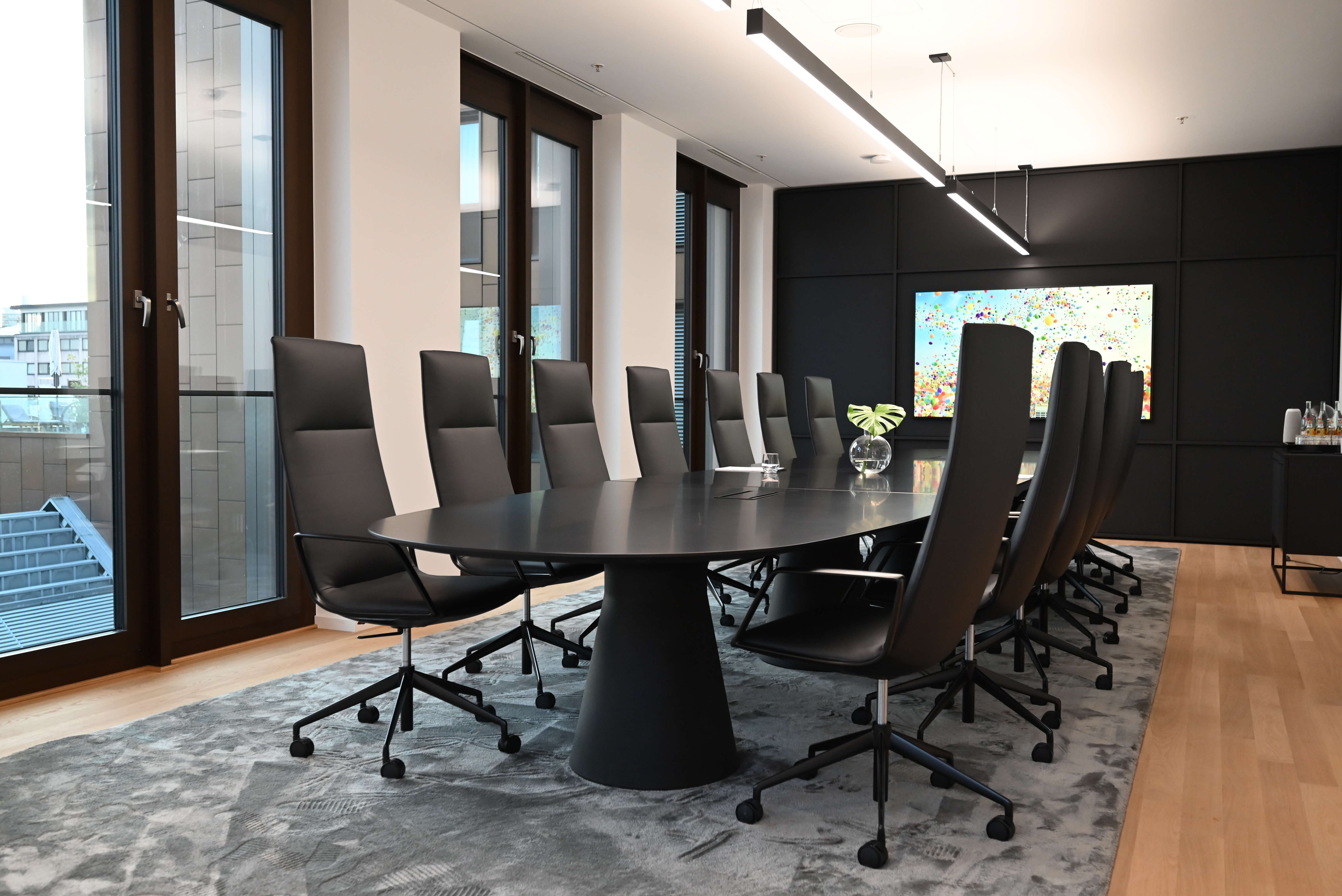 Club Room — 8-seat oval boardroom table on Floor 6, daylight through floor-to-ceiling windows.